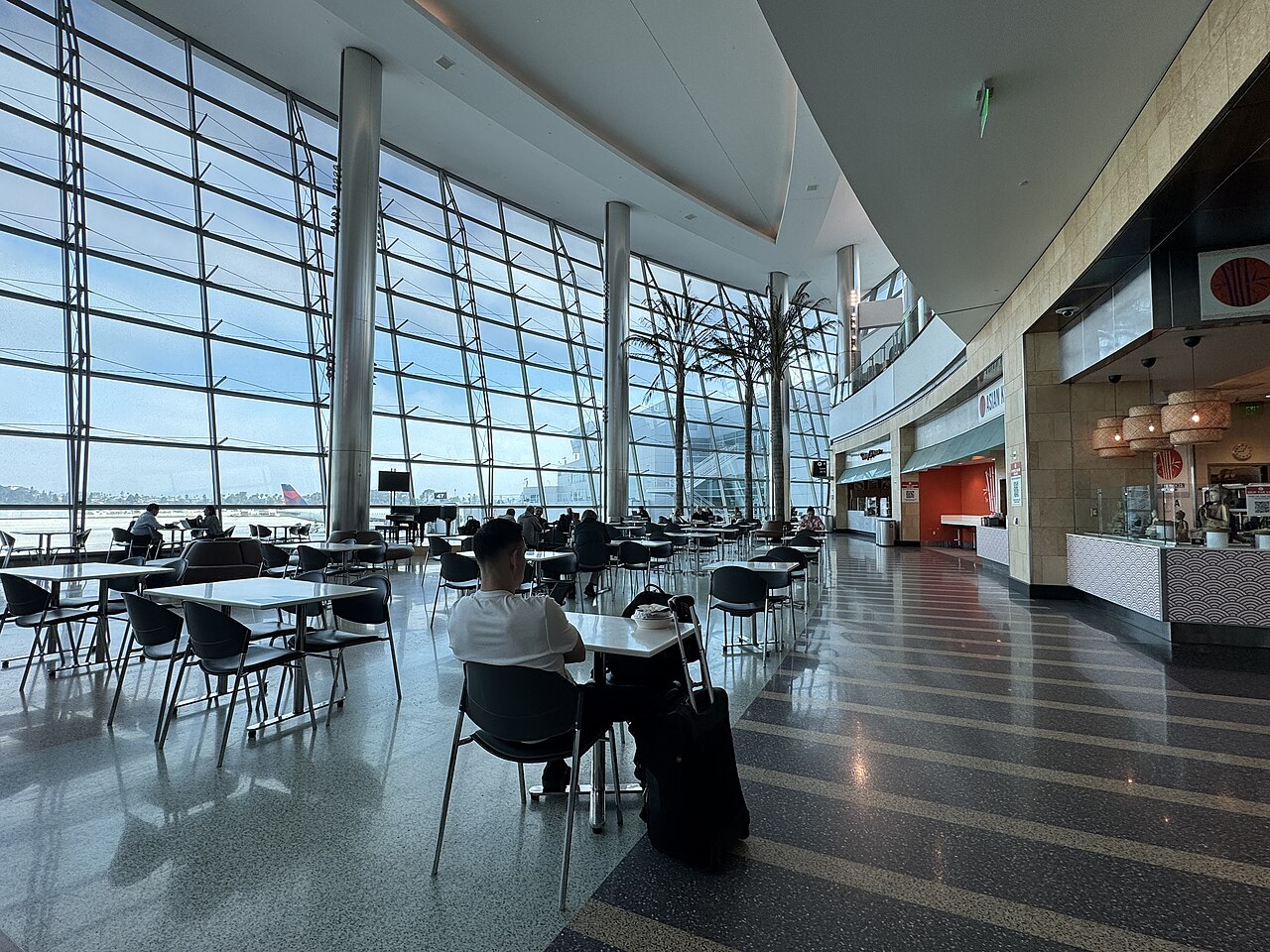 Seating beside floor-to-ceiling windows in the Terminal 2 concourse at San Diego International Airport