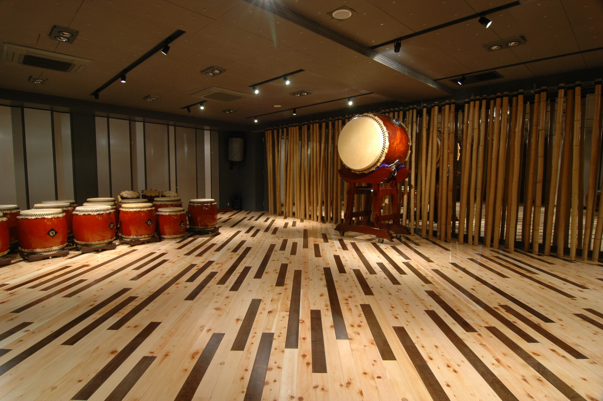 Taiko drums lined up on the wooden floor of the Taiko-Lab Aoyama studio