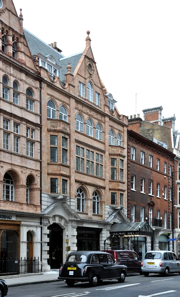 The red brick and terracotta frontage of Wigmore Hall on Wigmore Street, London, with its glass canopy over the entrance