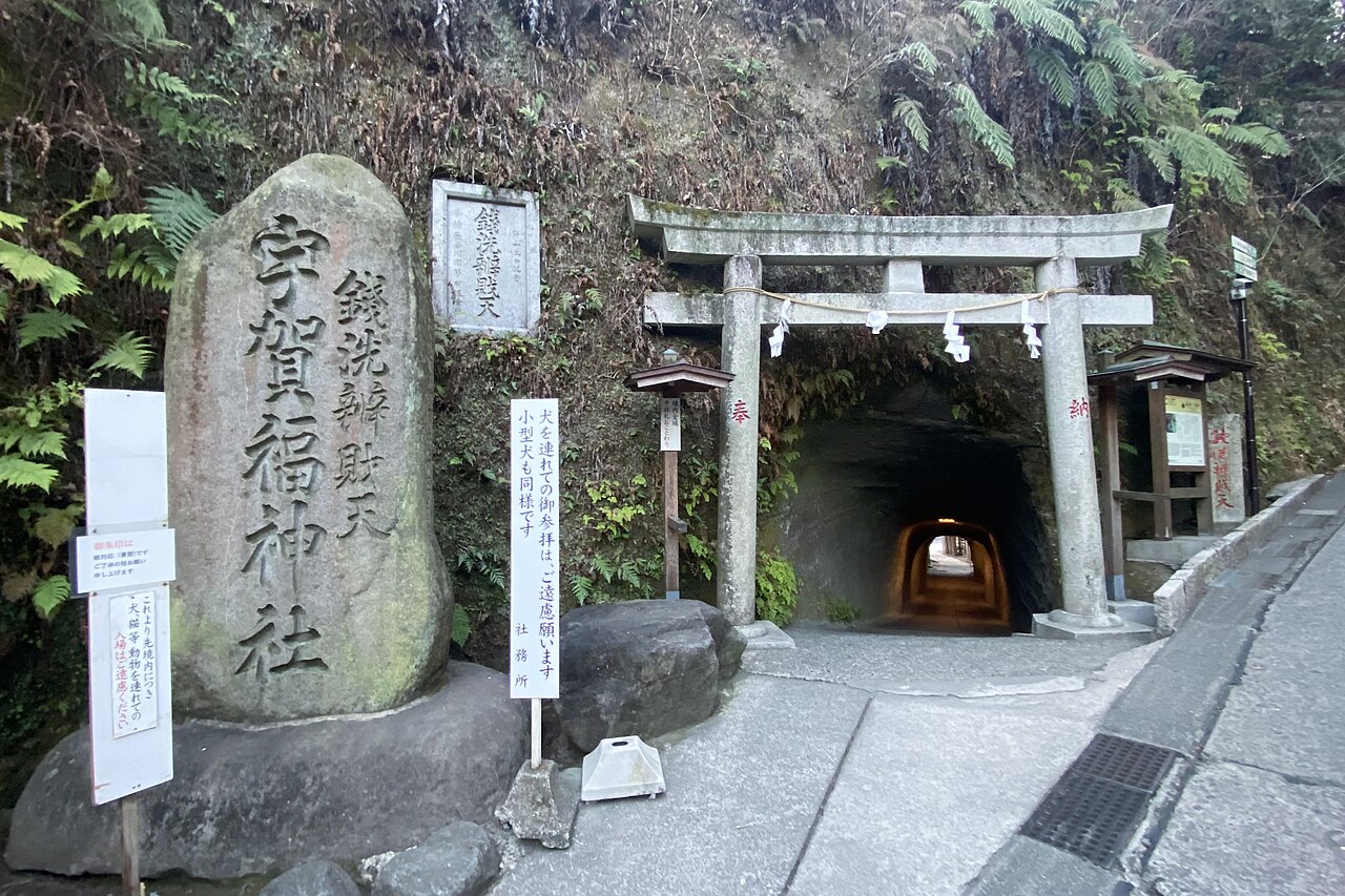 Stone torii and carved marker stone at the tunnel entrance to Zeniarai Benten Shrine in Kamakura