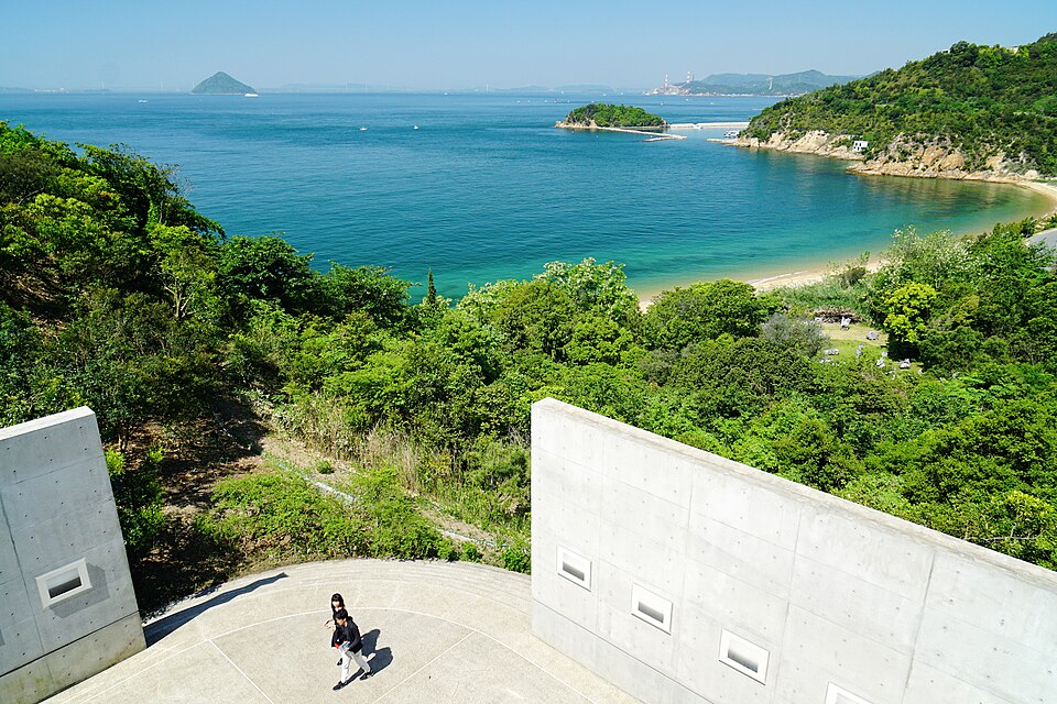 View from Benesse House Museum on Naoshima over the Seto Inland Sea, with concrete walls in the foreground and a sandy cove below
