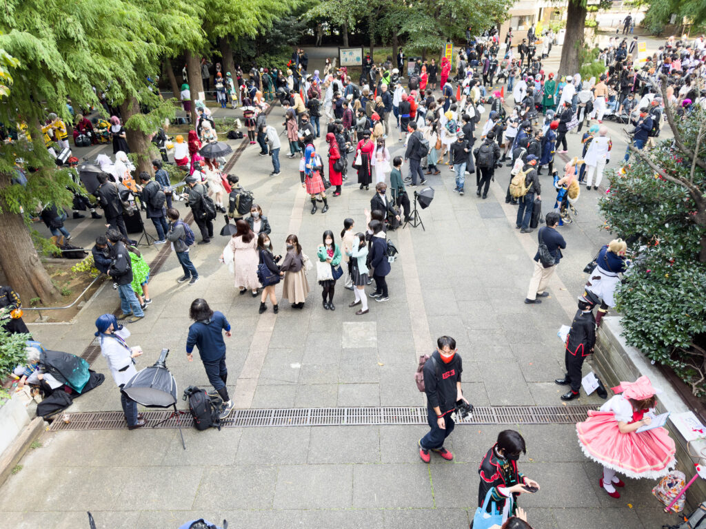 Cosplayers and photographers gathered along a tree lined path at the Ikebukuro Halloween Cosplay Festival