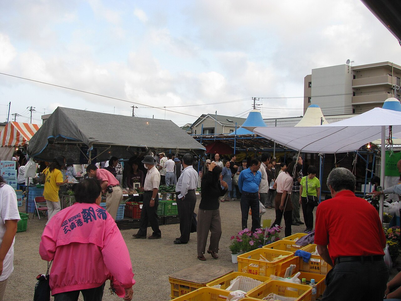 Shoppers browsing fish and produce stalls under tents at the Misaki Morning Market in Miura, Kanagawa