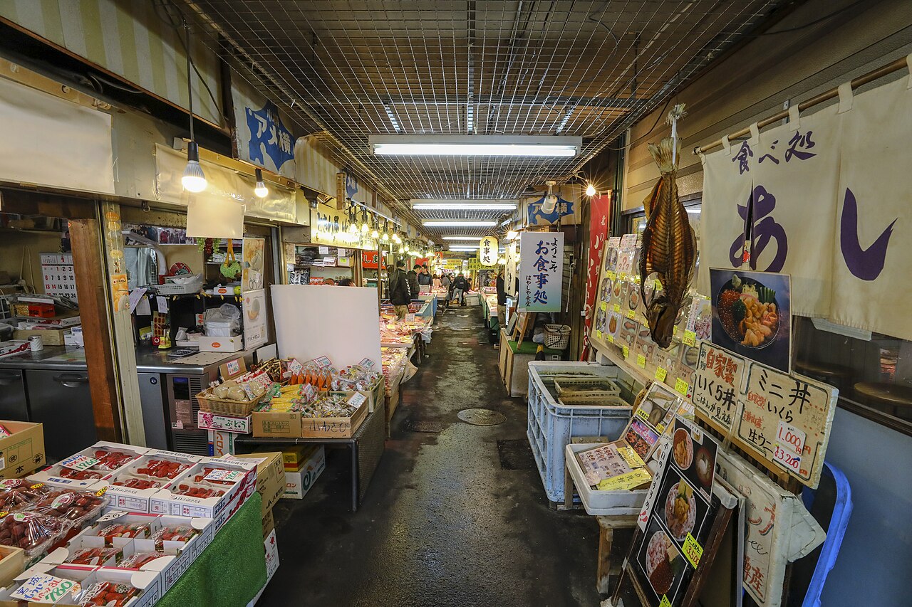 Seafood stalls and restaurant signs along the covered aisle of Otaru Sankaku Market