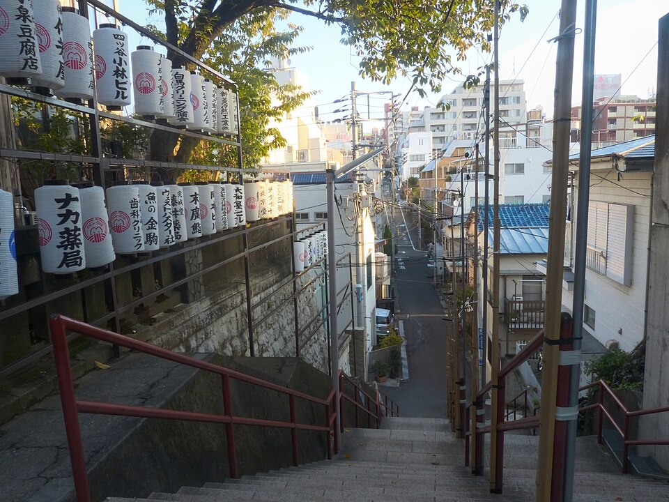 Looking down the stone stairs with red handrails below Suga Shrine in Yotsuya, Tokyo