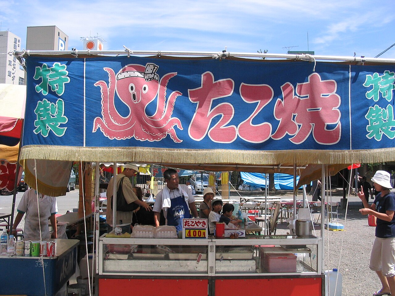 A takoyaki street food stall in Asakusa, Tokyo, with a blue octopus banner and a 400 yen price sign