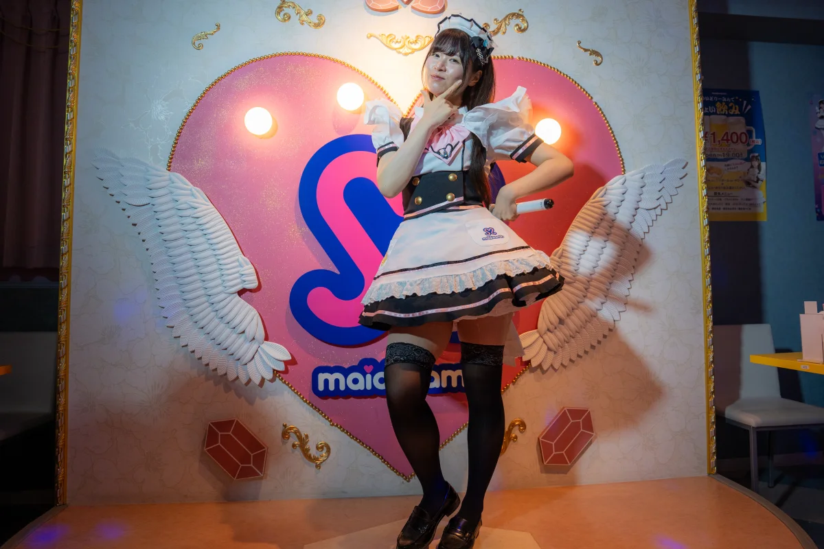 A maid posing on the heart shaped stage at a Maidreamin maid cafe in Akihabara