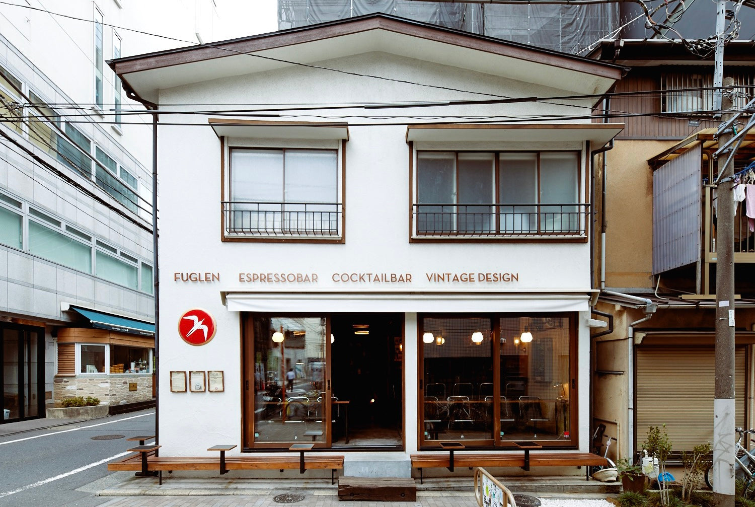 The white two storey Fuglen Tokyo shopfront on a quiet street in Tomigaya