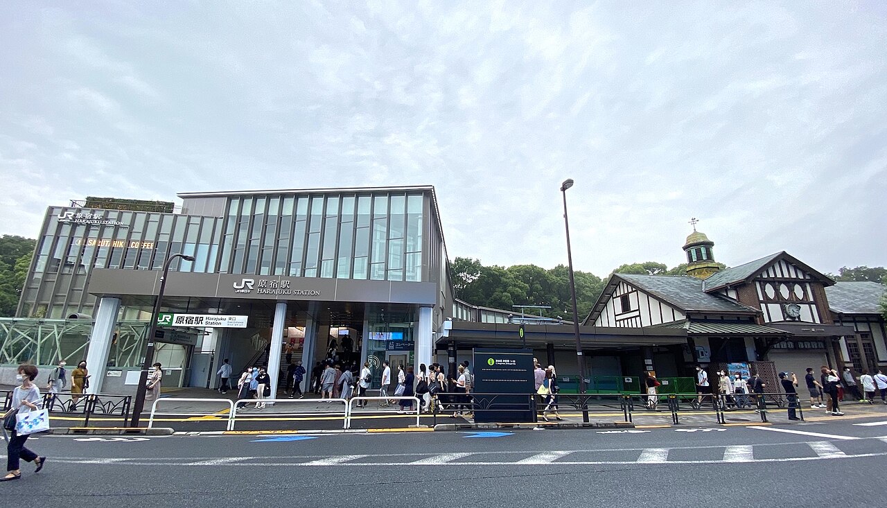 The new glass Harajuku Station building beside the old wooden station house in June 2020