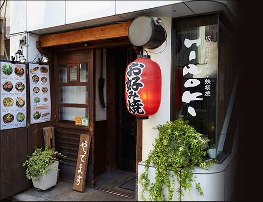 Entrance of Hiroki okonomiyaki restaurant in Shimokitazawa with a red okonomiyaki lantern and menu boards