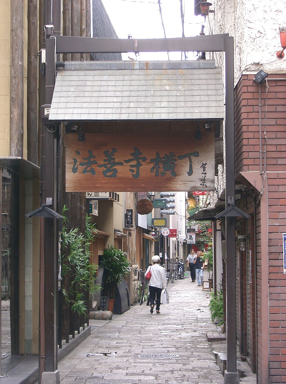 The wooden Hozenji Yokocho name board above the entrance to the stone-paved alley in Namba, Osaka