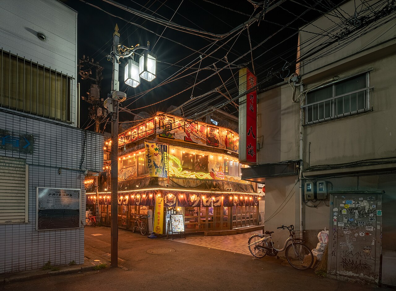 Izakaya Uloko in Nakano, Tokyo, lit up with lanterns at night on a quiet street corner