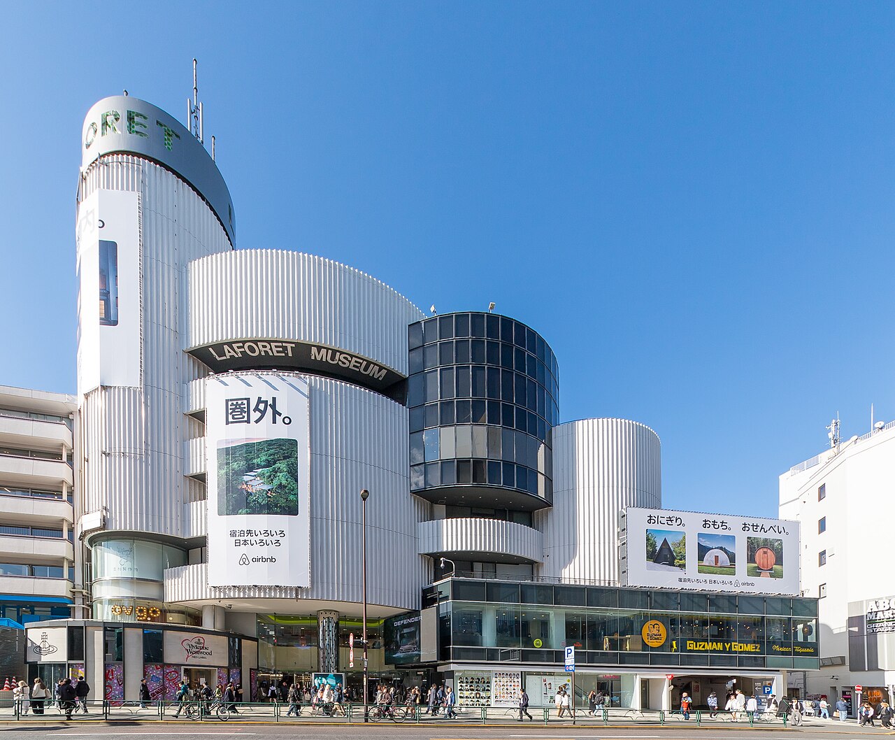 The rounded silver Laforet Harajuku building on the corner of Meiji Avenue and Omotesando under a blue sky