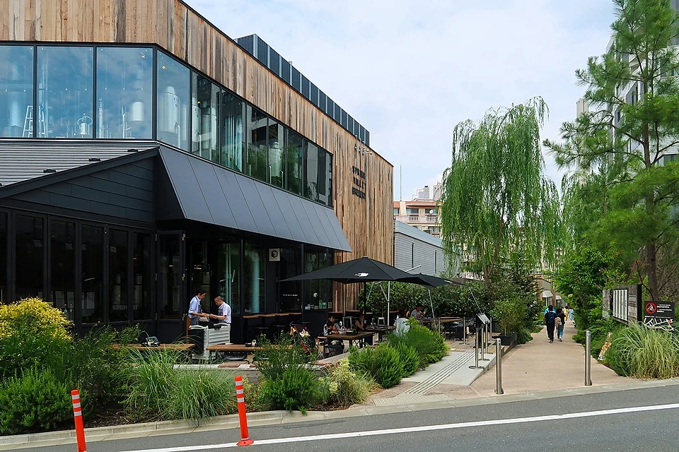 The timber and glass Spring Valley Brewery Tokyo building beside the planted walkway of Log Road Daikanyama in Shibuya