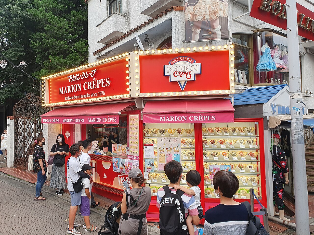 The red Marion Crêpes stand on Takeshita Street with its display of plastic crêpe models and customers queuing