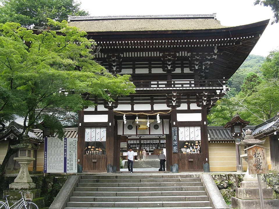 Two storey romon gate at Matsunoo Taisha shrine in western Kyoto, with stone steps and lanterns in front