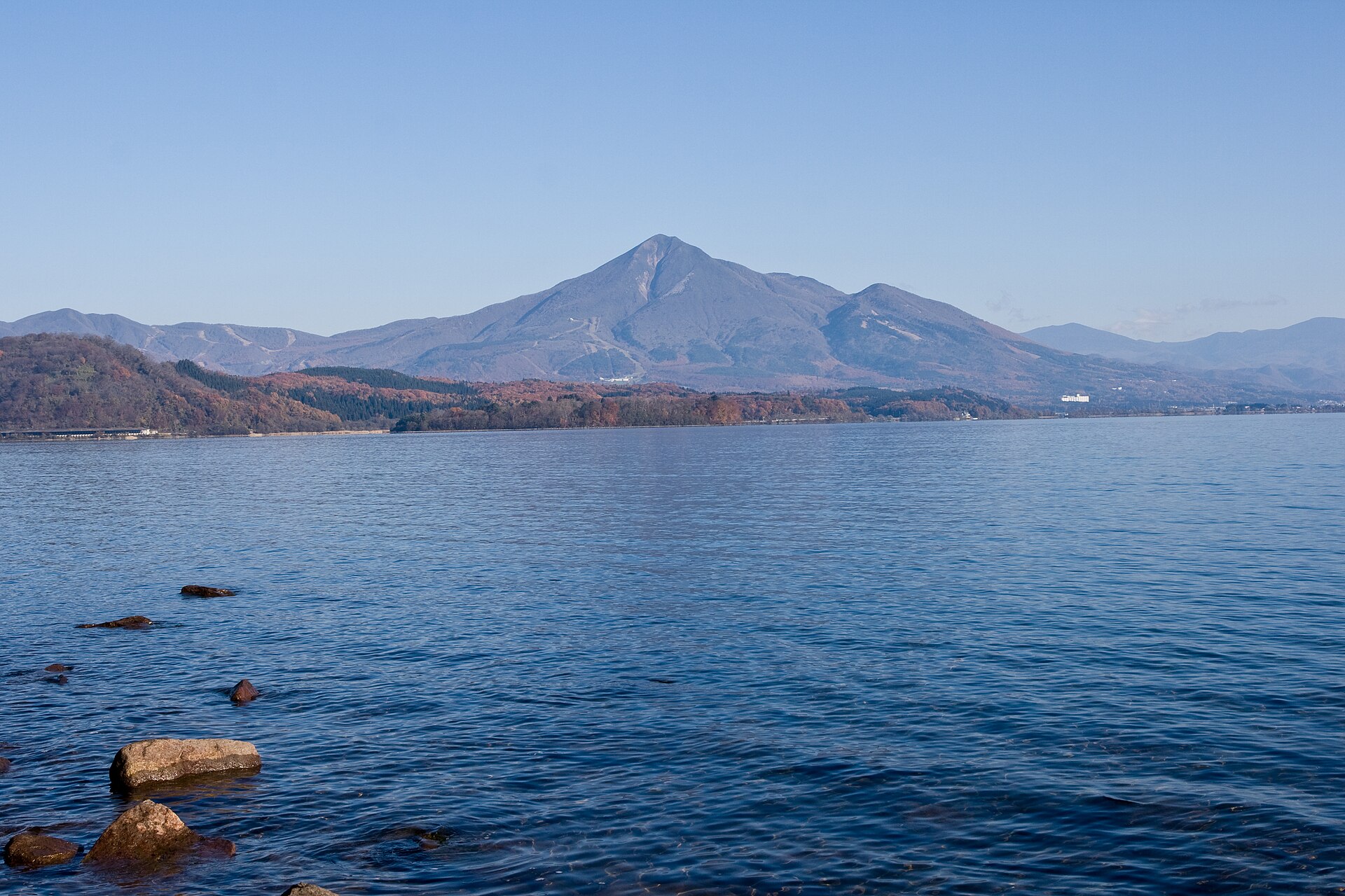 Mount Bandai rising above the calm blue water of Lake Inawashiro on a clear day