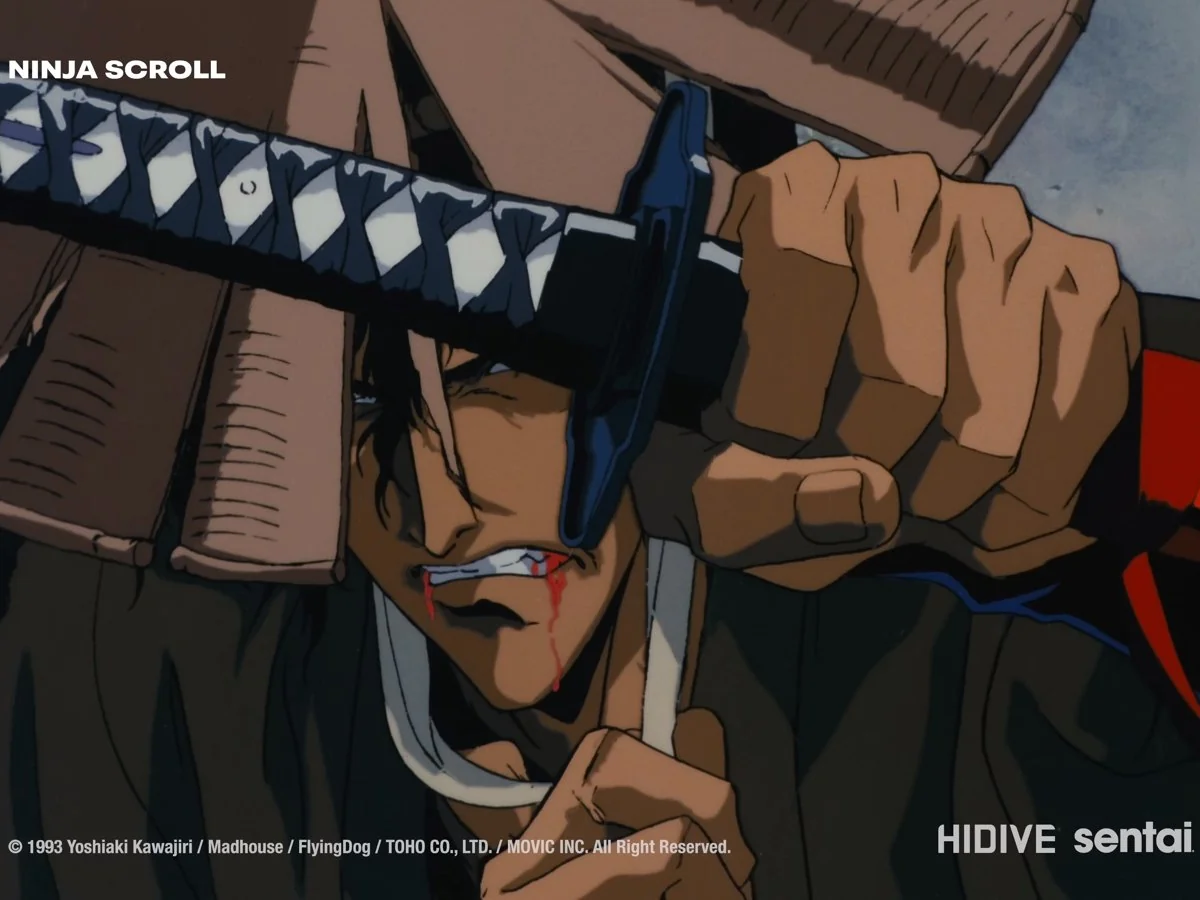 A swordsman bites down on a strip of cloth, blood at the corner of his mouth, as he grips a sword above his head beneath a wooden roof.