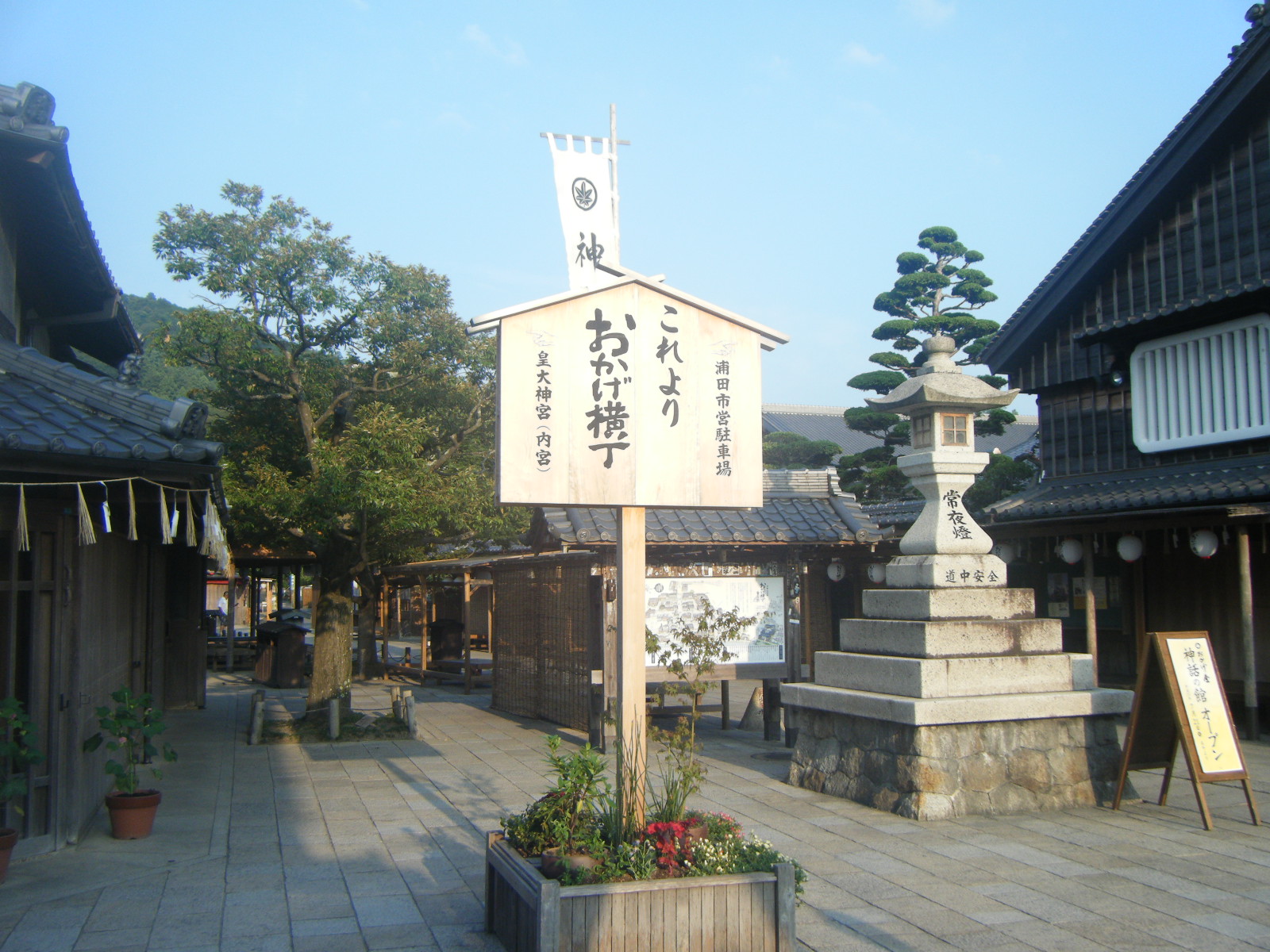 The wooden Okage Yokocho signpost and large stone lantern at the entrance to the street in Ise, Mie