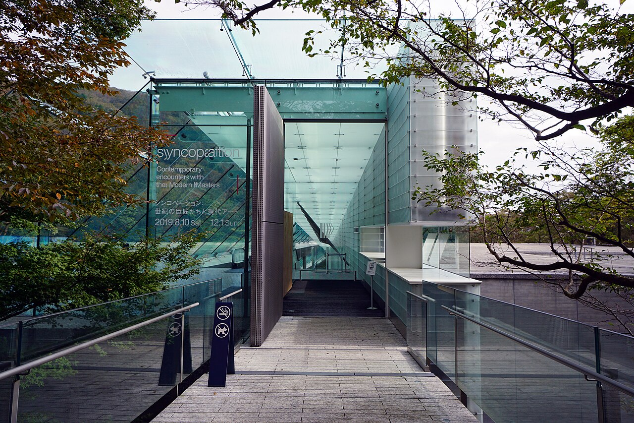 Glass entrance bridge of the Pola Museum of Art in Hakone framed by trees