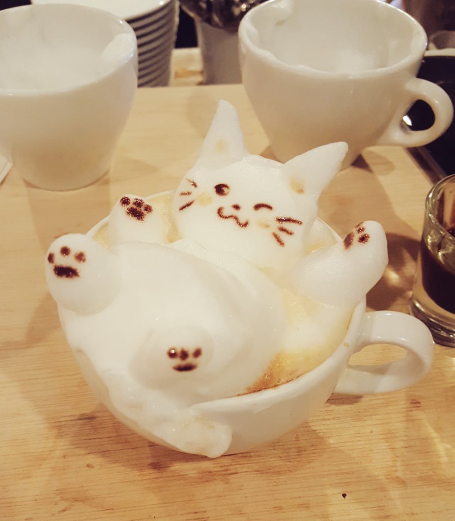 A 3D latte art cat made of milk foam lounging on a cup at Reissue in Harajuku