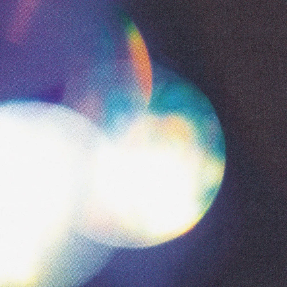 Blurred circles of white, blue and violet light glowing against a dark purple background