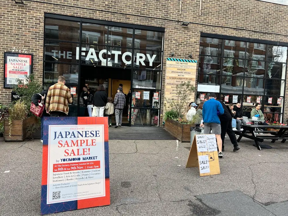 The Factory on Shacklewell Lane in Dalston, with Japanese Sample Sale by Yokimono Market boards outside and shoppers at the entrance