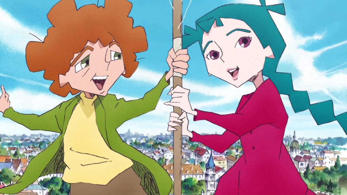 Giuseppe, with curly orange hair and a green jacket, and Pechka, with long teal hair and a red dress, hold on to a pole above a town of rooftops under a blue sky.