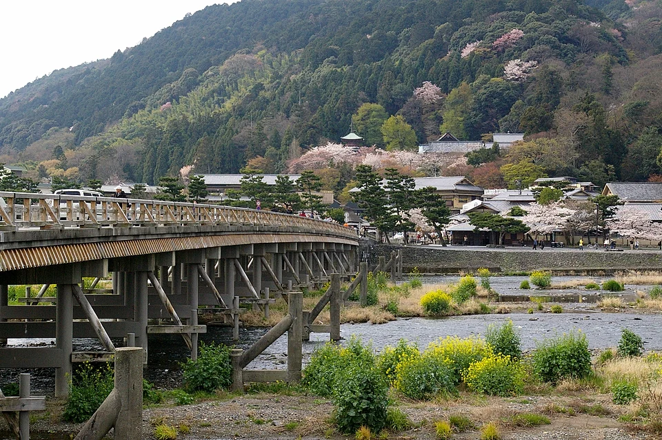 Togetsukyo Bridge crossing the Katsura River in Arashiyama, Kyoto, with cherry blossom on the wooded hillside behind