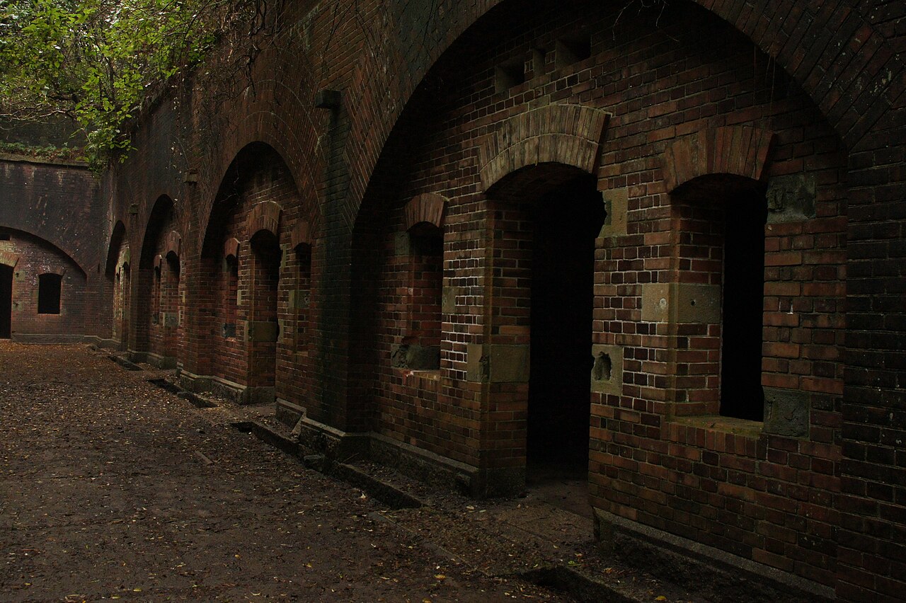 Red brick arched rooms of the old military fort ruins on Okinoshima in the Tomogashima islands, Wakayama, with trees growing above the walls